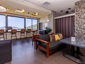 a living room with a couch and a bar at 旅館御宿Tabist Ritsurinsanso in Takamatsu