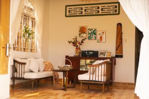 un salon avec deux chaises et une table dans l'établissement Nhà Nguyên Căn - Entire house - Nhà Mơ Homestay Bến Tre, à Xóm Bình Nguyên