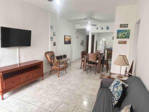 a living room with a couch and a flat screen tv at Apartamento muito gostoso a 20 m da Praia in Matinhos