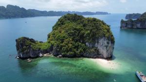 an island in the water with a boat in it at Calet Hotel in Cat Ba
