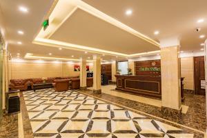 a large lobby with a waiting area and a stage at Calet Hotel in Cat Ba