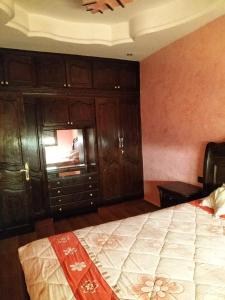 a bedroom with a bed and wooden cabinets at Agadir in Agadir