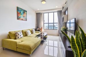 a living room with a yellow couch and a large window at 1br-Stunning View-Hana Apart in Ho Chi Minh City