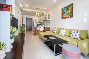 a living room with a green couch and a kitchen at 1br-Stunning View-Hana Apart in Ho Chi Minh City