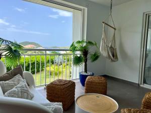 a living room with a couch and a large window at Appartement Sunrise in Cul de Sac