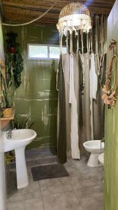 a bathroom with a sink and a toilet and a chandelier at Magia in Roldán +19 photos