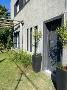 a building with a door and some plants in a yard at Magia in Roldán