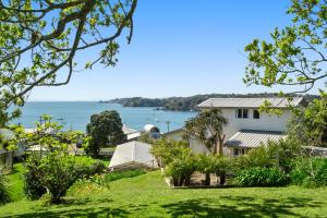 a house with a view of the water at Oneroa Bay View Apartment in Oneroa