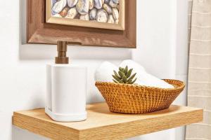 a bathroom shelf with a toilet paper dispenser and a basket at OASIS Punta Cana Apartment in Punta Cana