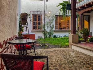 a patio with a table and chairs in a courtyard at Villa Dulé in Antigua Guatemala