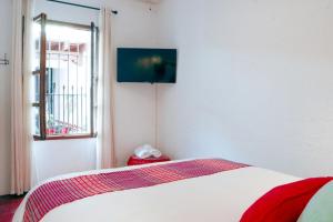 a bedroom with a bed with a window and a television at Villa Dulé in Antigua Guatemala +2 photos