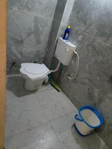 a bathroom with a toilet and a bucket at Kumkum guest house in Ujjain +34 photos