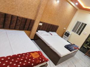 two beds in a small room with at Kumkum guest house in Ujjain