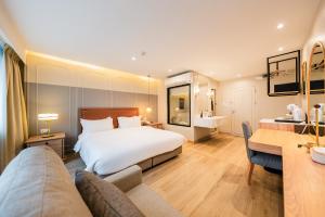 ein Hotelzimmer mit Bett und Schreibtisch in der Unterkunft THEE Bangkok by TH District in Bangkok + 52 Fotos