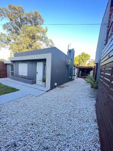 una casa con un camino de entrada de grava al lado de un edificio en Complejo Diolinda, en Mar del Plata