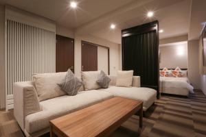 a living room with a couch and a bed at Hotel Naha City -Kokusai Street- in Naha