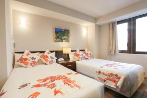 a hotel room with two beds and a window at Hotel Naha City -Kokusai Street- in Naha