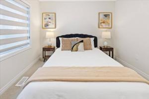 Un dormitorio con una gran cama blanca con dos lámparas. en NEW- Falls Serenity Sanctuary, en Thorold