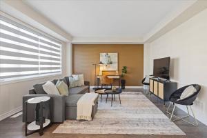 Una sala de estar con un sofá y un televisor. en NEW- Falls Serenity Sanctuary, en Thorold