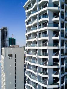 a white building with balconies on the side of it at Boton Blue Hotel & Spa in Nha Trang