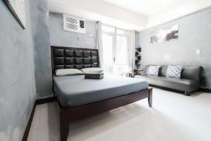 a bedroom with a bed and a couch at Cubao Manhattan Heights Residential Condo TA4N - Low Floor Studio with Pool & Balcony, 5 Mins Walk to Gateway Mall & Araneta Coliseum LRT MRT Cubao Quezon City - Staycations by SMS in Manila