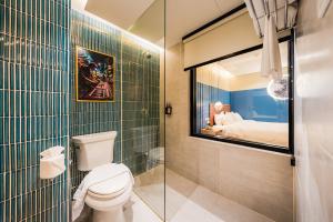 ein Badezimmer mit Toilette und Glasdusche in der Unterkunft THEE Bangkok by TH District in Bangkok