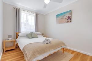 une chambre avec un lit avec deux chaussures dessus dans l'établissement Sanctuary Cottage - Family and Pet Friendly, à Sanctuary Point