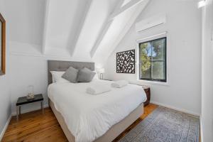 Un dormitorio blanco con una cama grande y una ventana. en Braeside Cross, en Blackheath