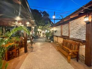 a patio with a bench and a brick building at Luang Prabang Xayana Hotel in Luang Prabang