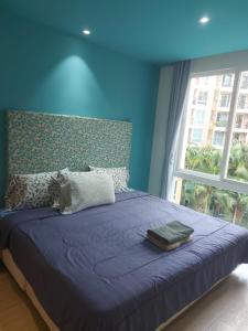 a blue bedroom with a bed with a large window at Atlantis Condo Resort in Jomtien Beach +41 photos