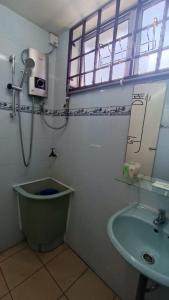 a bathroom with a sink and a toilet and a window at Lenggong GEM 16 Homestay in Kampong Ulu Jepai +9 photos