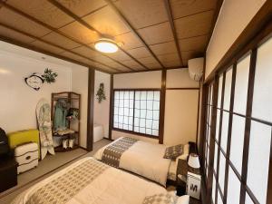 关市湯沢雪の宿 YUZAWA Snow Inn-Ski IN Ski OUT的有两张床和一扇窗户的卧室