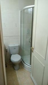ジャカルタにあるApartment Ambassador 2 Kuninganのトイレとガラスのシャワー付きのバスルーム