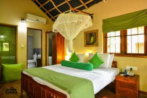 a bedroom with a large bed with green pillows at The Other Corner Habarana in Habarana