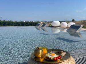 a tray of food on a table next to a pool at Oikos Sani Suites in Sani Beach