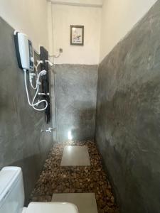 a bathroom with a toilet and a phone on the wall at Ridge Boundary View in Dambulla