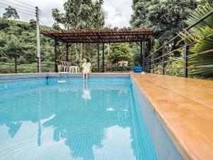 a little girl is sitting in a swimming pool at Tantai Eco Farm Stay At Khao Yai in Ban Sap Noi