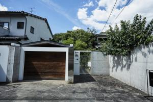 a garage with a wooden door next to a house at Shibi in Nara