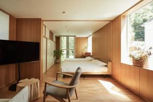 a bedroom with a bed and a tv and a chair at Shibi in Nara
