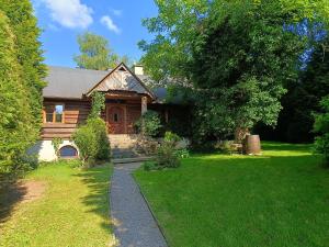 una casa di tronchi con un sentiero che conduce ad essa di Amigówka a Wieliczka