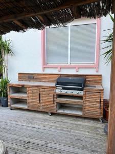 un grill sur une terrasse en bois avec une fenêtre dans l'établissement Design Apartment Bali in Rödersheim-Gronau, à Rödersheim-Gronau 1 autre photo