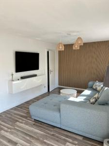 un salon avec un canapé bleu et une télévision à écran plat dans l'établissement Design Apartment Bali in Rödersheim-Gronau, à Rödersheim-Gronau