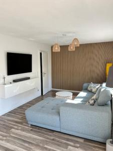 un salon avec un canapé et une télévision à écran plat dans l'établissement Design Apartment Bali in Rödersheim-Gronau, à Rödersheim-Gronau