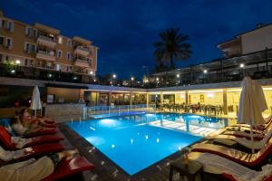 a pool at night with lounge chairs and a hotel at Kleopatra Fatih Hotel in Alanya