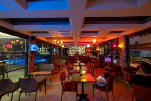 a restaurant with tables and chairs and a bar at Kleopatra Fatih Hotel in Alanya