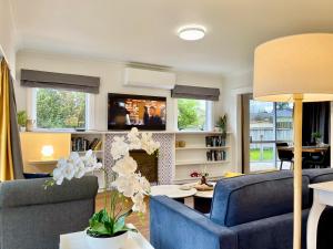 a living room with two blue chairs and a fireplace at Quiet, private and 5-bedroom holiday house in Hamilton