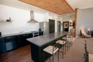 a kitchen with a large counter with stools in it at Casa Del Caird in Methven +34 photos