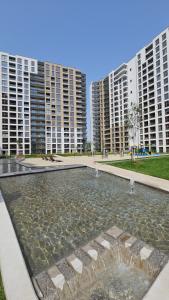 einen Brunnen vor einigen hohen Gebäuden in der Unterkunft Nova Letnica Sea Apartaments in Gdańsk Letnica