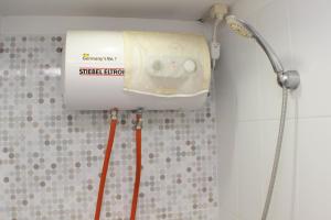 a shower in a bathroom with aiger erdir at Cozy and Warm Studio at Grand Sentraland Karawang Apartment By Travelio in Karawang +7 photos