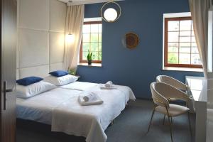 a blue bedroom with a bed and a chair at Noclegi Zakład Aktywności Zawodowej w Świerzawie in Świerzawa +48 photos